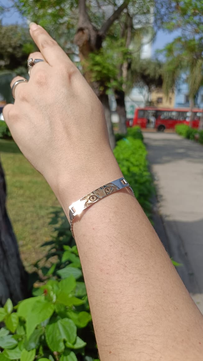 Pulsera de acero con la mirada de un gato grabada, en la muñeca